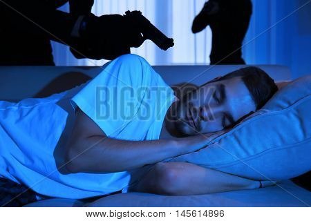 Armed thieves entering a house and threatening man