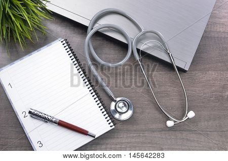 Doctor workplace with a stethscope at wooden table