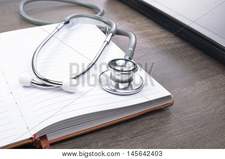 Stethscope on top of notebook with laptop
