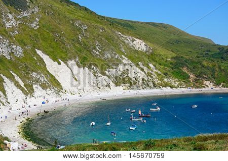 LULWORTH COVE, UNITED KINGDOM - JULY 19, 2016 - View looking down the hillside towards the cove with tourists enjoying the beach Lulworth Cove Dorset England UK Western Europe, July 19, 2016.