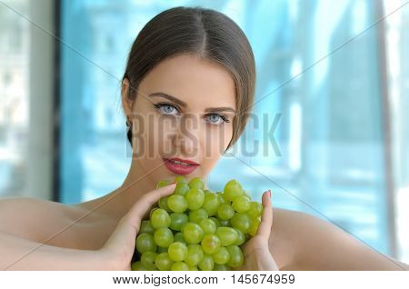 Girl Holding Grapes In Front Of Her Breasts