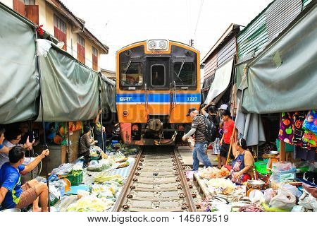 SAMUT SONGKHRAM THAILAND - SEPTEMBER 4 2016 : Mae Klong Market placed all product on railroad all vendors have to move product away when the train passes market.