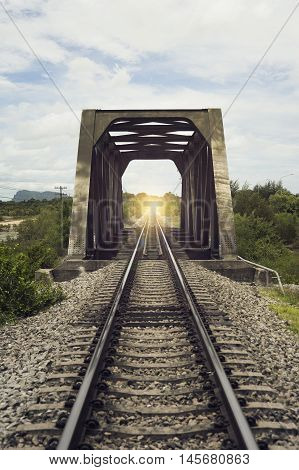view of the length of railway and old steel bridge with green tree at left and right side of railway,filtered image,light effect added,selective focus,mean 