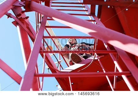 quality control of mobile communication on a base station. tower technician on telecommunication tower calling on mobile phone. the concept of a test call. bottom view