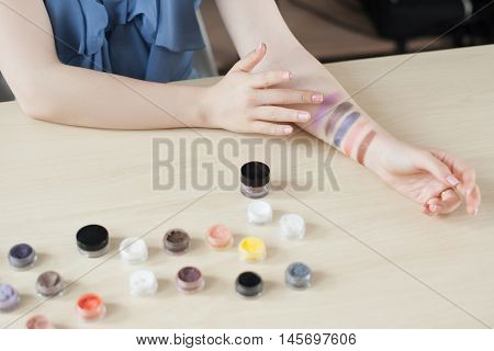 Make up artist testing eyeshadow colors. Woman stylist trying cosmetics color on her hand. Professional coloring, visagiste, swatch concept