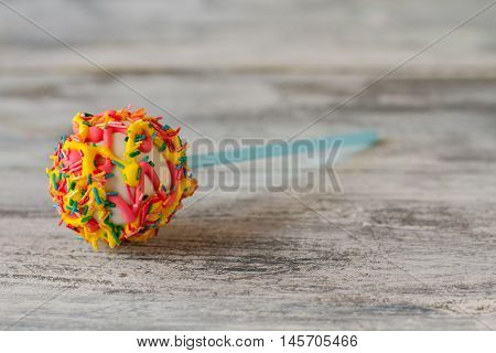 Candy with frosting and sprinkles. Colorful cake pop. Dessert will lift your mood. Be happy and energetic.