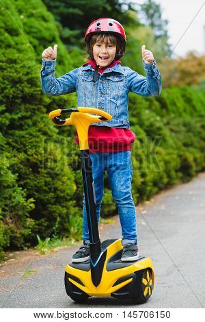 Happy boy riding on hoverboard or gyroscooter outdoor.