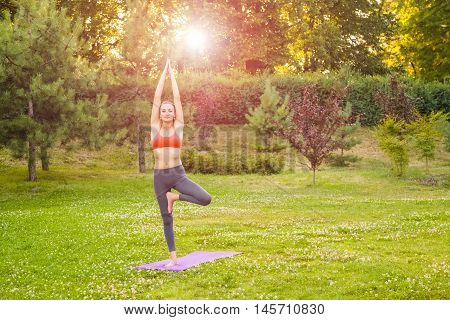 Young Woman Practicing Yoga In The Park.