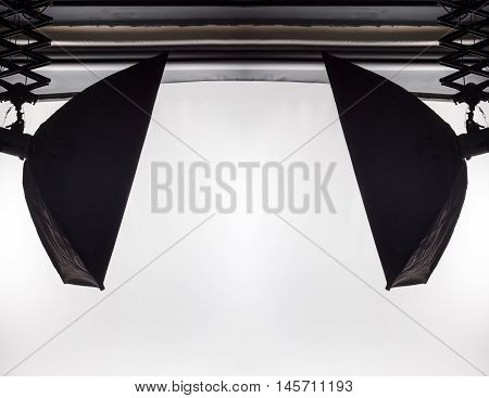 Empty photo studio with lighting equipment and white paper background ready for photoshoot