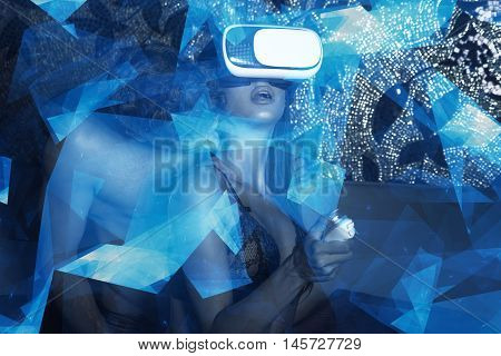 Sexy woman using VR headset with remote control and lover at night with polygons virtual reality