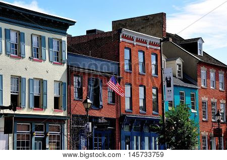 Baltimore Maryland - July 22 2013: 18th and 19th century brick buildings line the Thames Street waterfront and house trendy shops pubs and restaurants at historic Fells Point