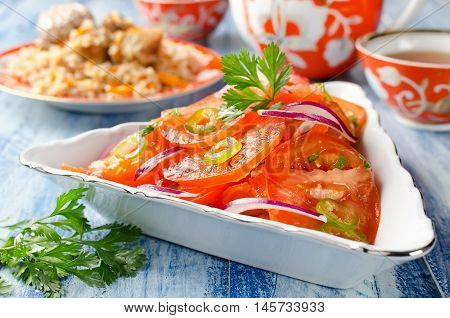 Vegetable salad from tomatoes with onions and hot peppers. Traditional Uzbek salad that is served with pilaf