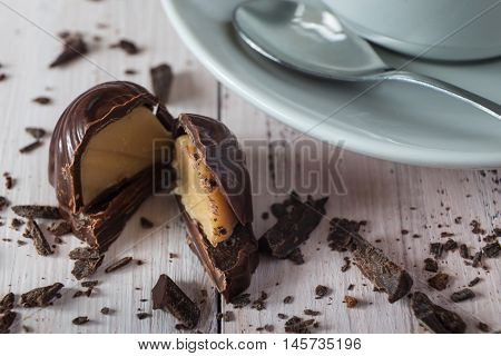 Close up of a chocolate candy a cup of coffee and chocolate crumbs
