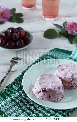 Cream and cherry dessert on a white plate and a fork