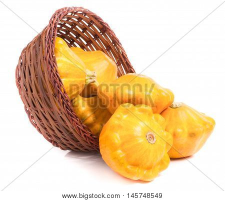yellow pattypan squash in a wicker basket isolated on white background.