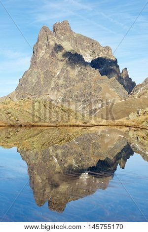 Midi Dossau Peak reflected in a lake. Ossau Valley, Pyrenees National Park, Pyrenees, France.
