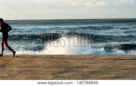 man runing on the beach in the early morning during hurricane hermine September 2016. Picture is taken at Ocean Beach Fire Island