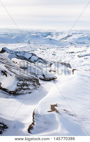 Snow covered tor landscape in winter Kinder Scout Derbyshire England UK