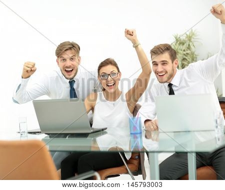 Team of three work colleagues with their arms raised in celebrat