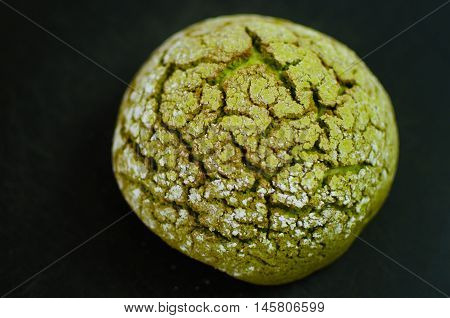 Japanese bread matcha melon pan on black background