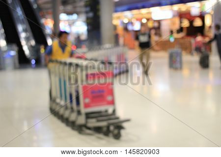 Abstract Background, Blurred Image Of A Man Working With Trolleys Luggage In Corridor Of Terminal Pa