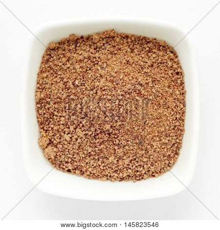 Organic powder of Indian Jujube (Ziziphus mauritiana) in a white ceramic bowl. Isolated on white background. Top view.