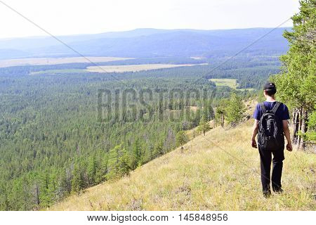 Tourist walking on the top of a high mountain