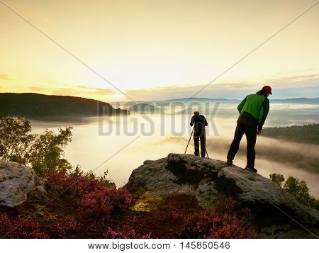 Hiker Look Down Into Fogy Valley. Photographer Stay On Cliff And Takes Photos.