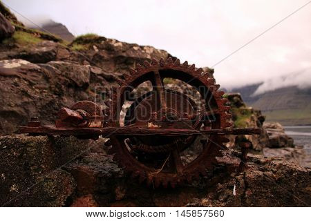 Rusted iron wheal at the coastline in the Faroe Islands