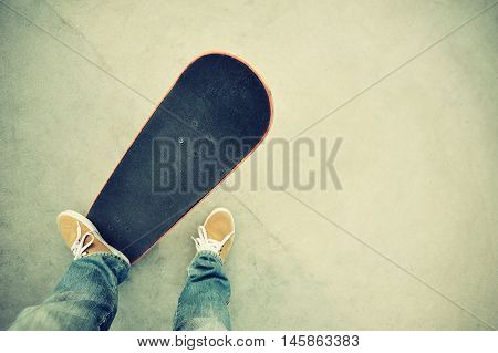 closeup of skateboarder legs skateboarding at skatepark
