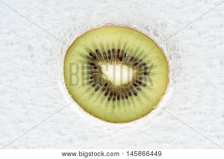 Halve of  kiwi with bubble in water.