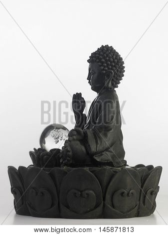 black Buddha statue in a sitting position on the white background