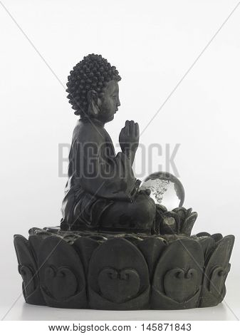 black Buddha statue in a sitting position on the white background
