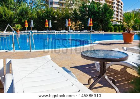 Swimming pool in spa resort. Sunbeds awaiting tourists.