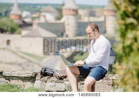 Attractive man working in your home garden. Young man working talking with smart phone in outdoors.