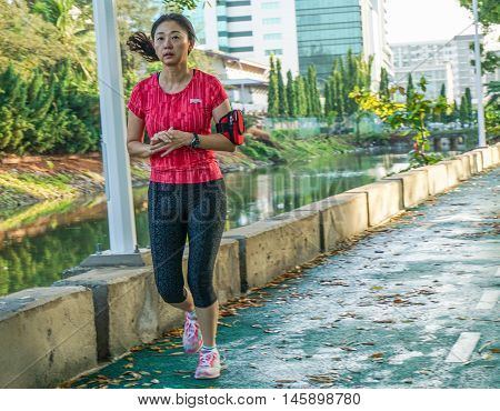 Kota Kinabalu,Sabah-Aug 31,2016:Malaysian joggers run past a calm morning view of Lagoon at Sutera Harbour Resort,Kota Kinabalu,Sabah,Borneo on 31st Aug 2016