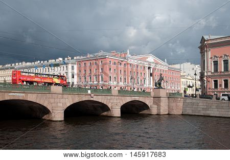 SAINT - PETERSBURG, RUSSIA - SEPTEMBER 5, 2016: Hop-On Hop-Off. City Tour Bus rides on The Anichkov Bridge with The Horse Tamers by Peter Klodt across The Fontanka River near Nevsky Avenue