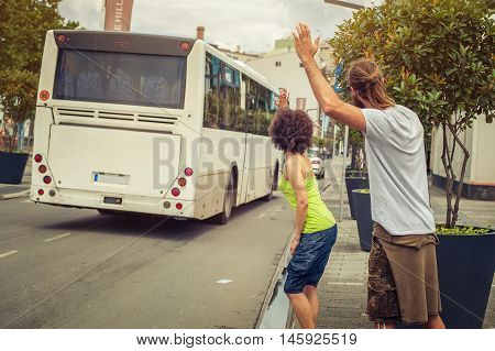 Young Couple Waving Goodbye To Their Friends On The Bus