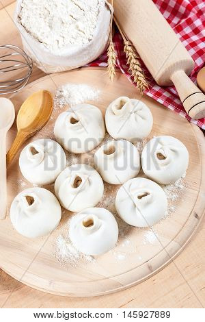 Baking ingredients for cooking manti dumplings on a wooden board.