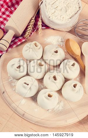 Baking ingredients for cooking manti dumplings on a wooden board.