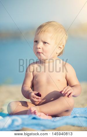 Baby playing with toys on the sandy beach near the sea. Cute little kid in  sand on tropical beach. Ocean coast.