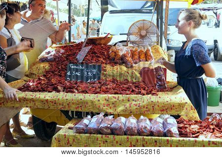 St Aygulf, Var, Provence, France, August 26 2016: A Stall Holder Selling Sun Dried Tomatoes From A P