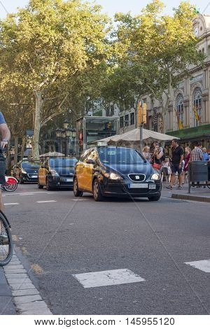 Barcelona Spain - July 23 2016: Taxi car goes by Ramblas avenue in Barcelona City