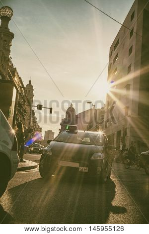 Taxi car goes Barcelona City crossing a ray of light