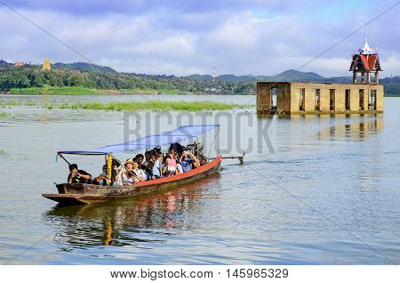 OLD WAT WANG WIWEKARAM SAGKLABURI 12 OCT 2014:Tourists in a long tail boat at the entrance of The Sunken Temple Wat Wang Wiwekaram Kanchanaburi Thailand.