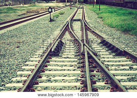 Two railways tracks merge close up.Vintage tone