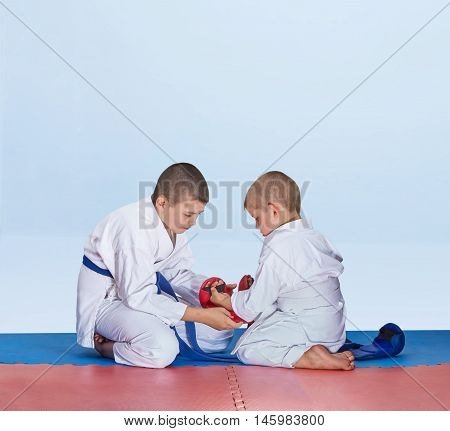 Red overlays little brother helping  to dress brother