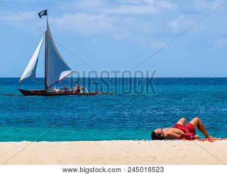 Sailing boat at white Puka beach of Boracay island Philippines
