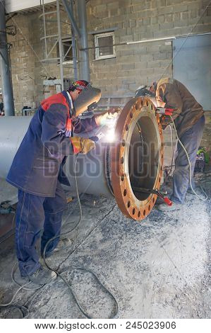 Two Welders Are Welded, By Manual Arc Welding, A Flange Dn 800 To The Pipe