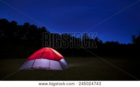 Nylon Tent Pitched In A Field With Bright Stars Above